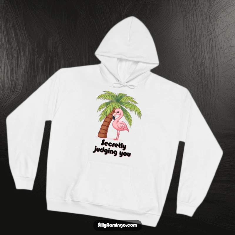 Funny hoodie showcasing a pink flamingo's head peeking intrigueingly from behind a leafy palm tree, offering a hint of island fun.