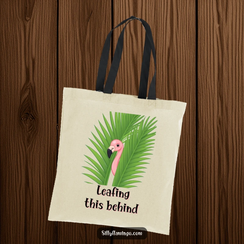 Funny flamingo peeking out from a large green palm leaf on a durable tote bag, adding humor to everyday carry.